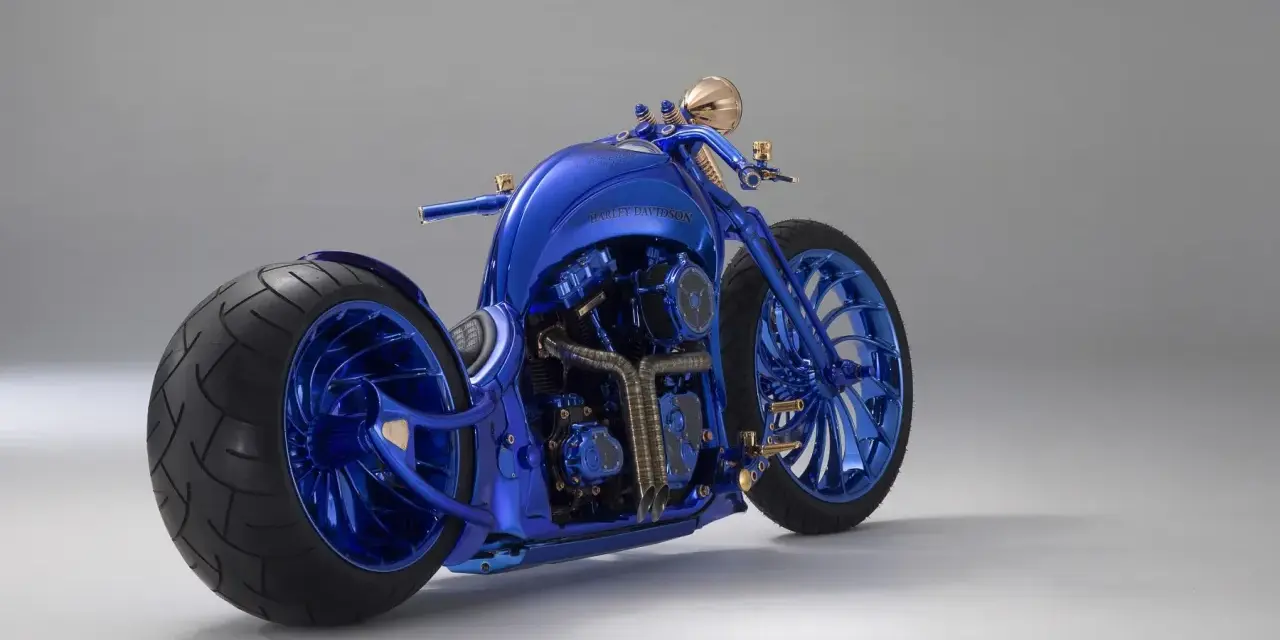 Błyszczący, niebieski Harley-Davidson, prawdopodobnie najdroższy motor na świecie, z masywnymi kołami i złotymi detalami.