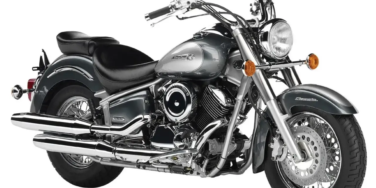 Szary motocykl Yamaha Drag Star 1100, klasyczny cruiser z chromowanymi elementami. Dane techniczne tego modelu to jego moc i styl.
