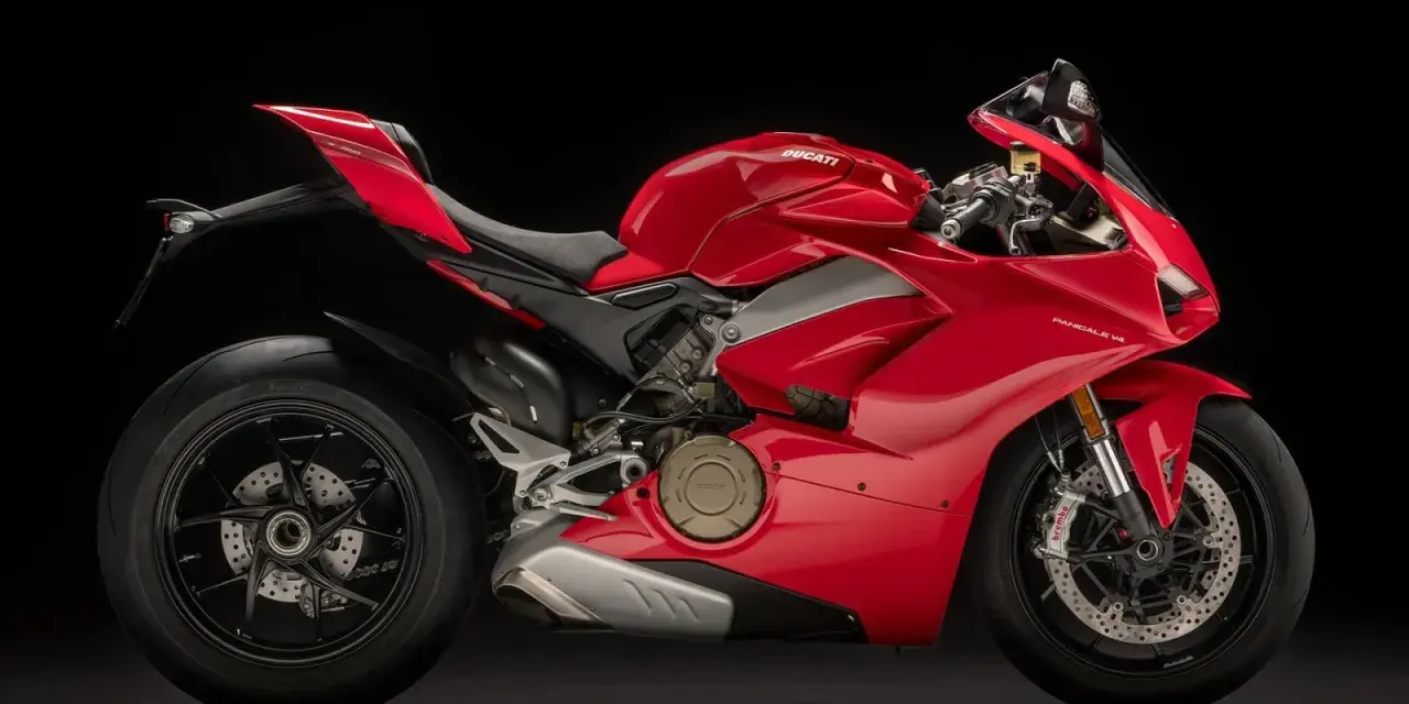Czerwony motocykl Ducati Panigale V4 na czarnym tle. Poznaj jego imponującą moc i sprawdź, jaka jest jego ducati panigale v4 cena.