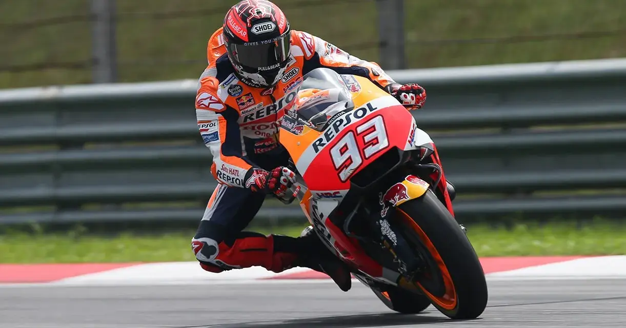 Motocyklista w kombinezonie Repsol Honda z numerem 93 wykonuje ostry zakręt, stosując technikę przeciwskrętu.