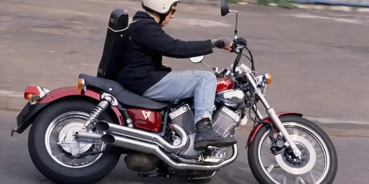 Motocyklista na czerwonym Yamaha Virago 535, z futerałem na instrumenty z tyłu. Dane techniczne tego modelu są imponujące.