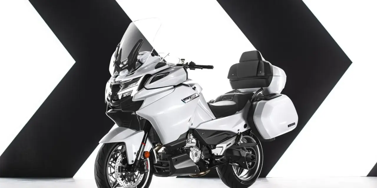 Biały, luksusowy motocykl turystyczny z kuframi, gotowy na dalekie podróże. Chińskie motocykle turystyczne oferują komfort i styl.