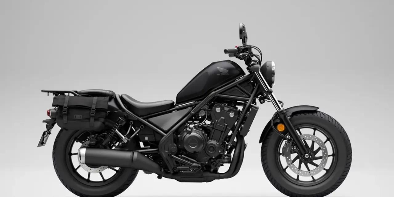 Czarny motocykl Honda Rebel 500 z sakwami, gotowy na podróż. Jego prędkość maksymalna pozwala na swobodne pokonywanie tras.