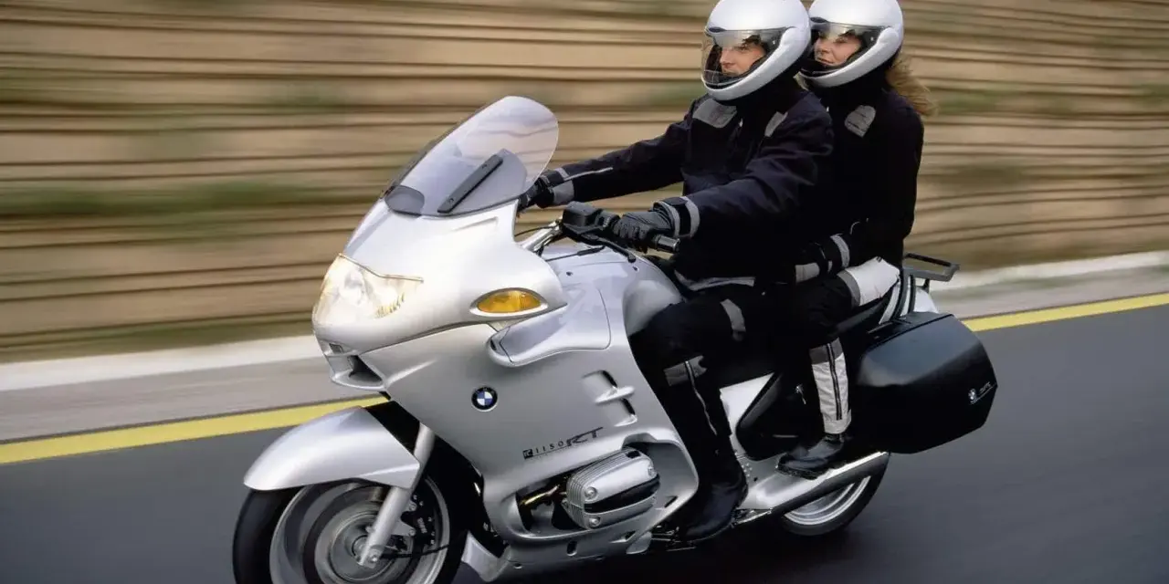 Para podróżuje na srebrnym BMW R 1100 RT. Choć motocykl ten ma swoje wady, podróż wygląda na komfortową.