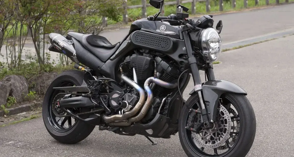 Czarny Yamaha MT-01 z customowym wydechem i sportowymi dodatkami, gotowy na jazdę po krętych drogach.