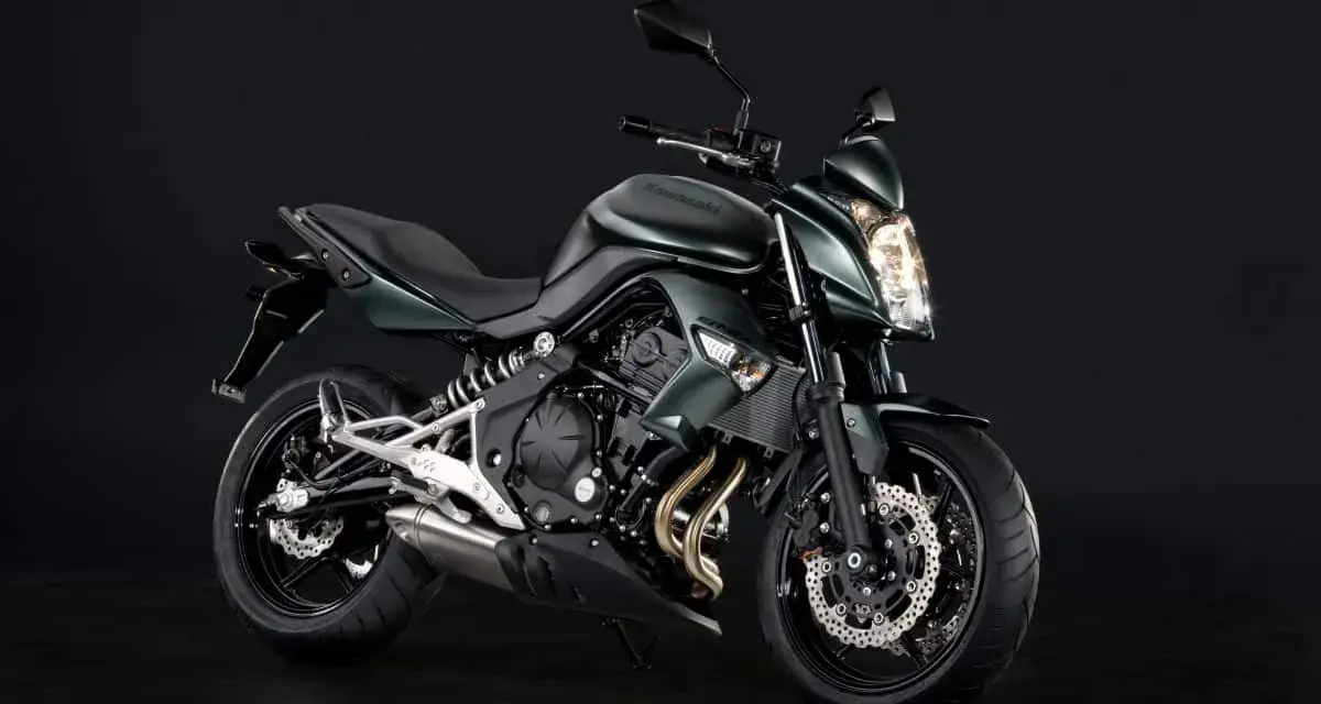 Zielony motocykl Kawasaki ER6N z ciemnym tłem.
