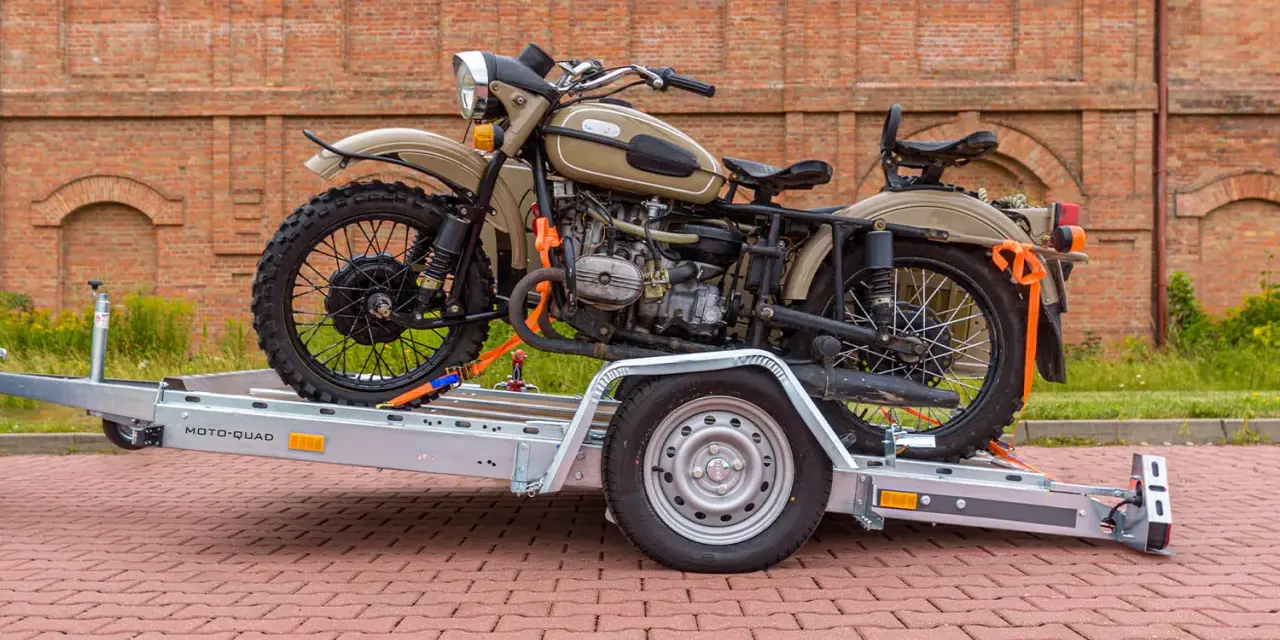 Jak przewieźć motocykl na zwykłej przyczepie? Oto przykład z użyciem pasów transportowych do zabezpieczenia ciężkiego motocykla.