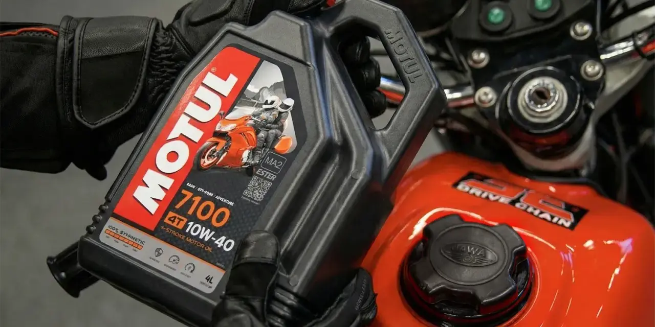 Rękawice motocyklisty trzymają olej Motul 7100 10W-40. Pytanie: co ile wymieniać olej w motocyklu?