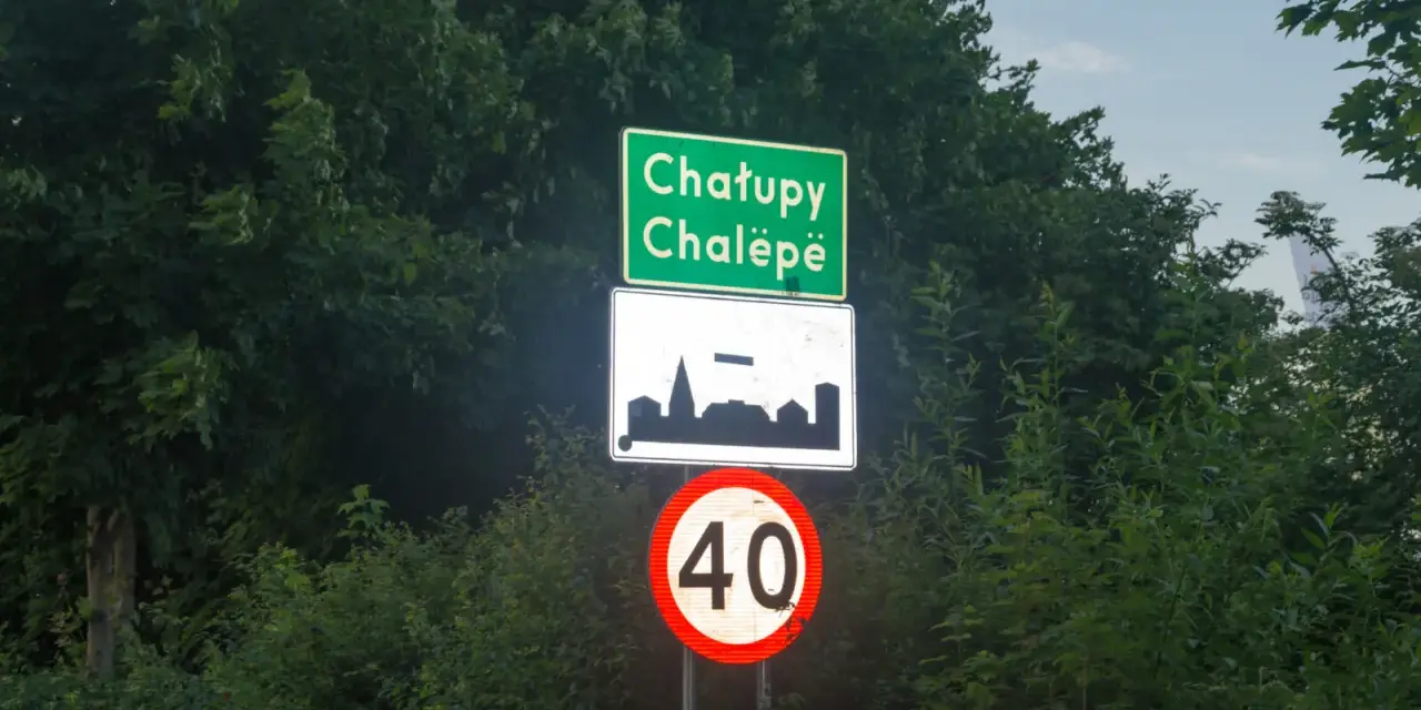 Znak d42: Chatupe Chalëpe, zarys zabudowań i ograniczenie prędkości do 40 km/h.