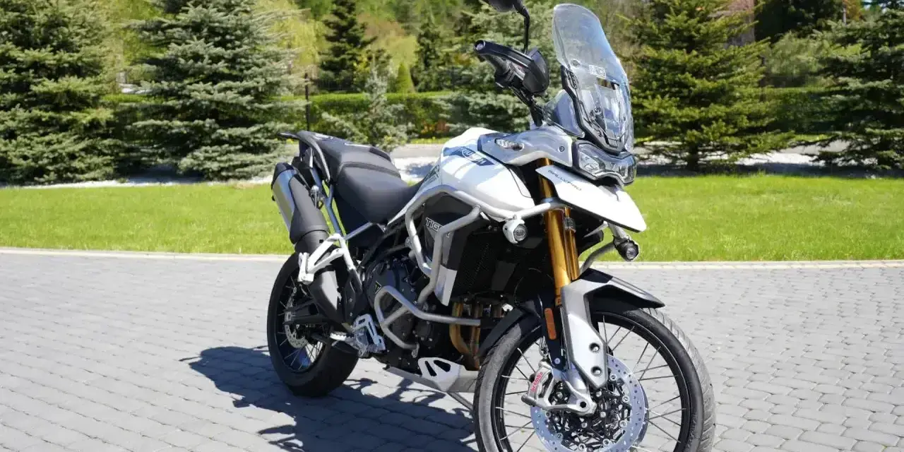 Biały motocykl Triumph Tiger 900 na brukowanej nawierzchni. Poznaj jego imponujące triumph tiger 900 dane techniczne.