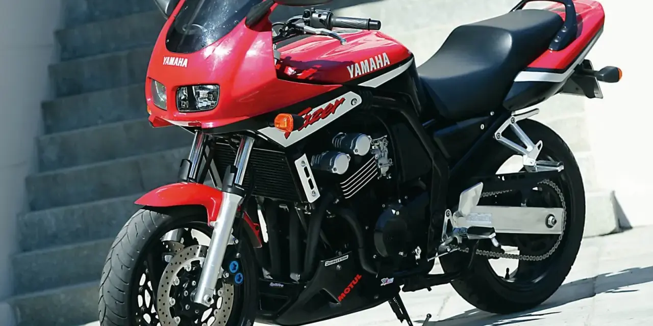 Czerwony motocykl Yamaha Fazer z czarnym siedzeniem i detalami, gotowy do jazdy.