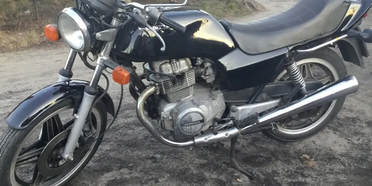 Czarny motocykl Honda CB250T z lat 80. stoi na ziemi.
