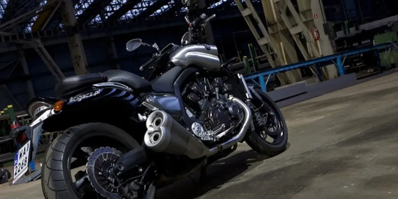 Potężny motocykl Yamaha V-Max 1700 z chromowanymi elementami, stojący w industrialnym wnętrzu.