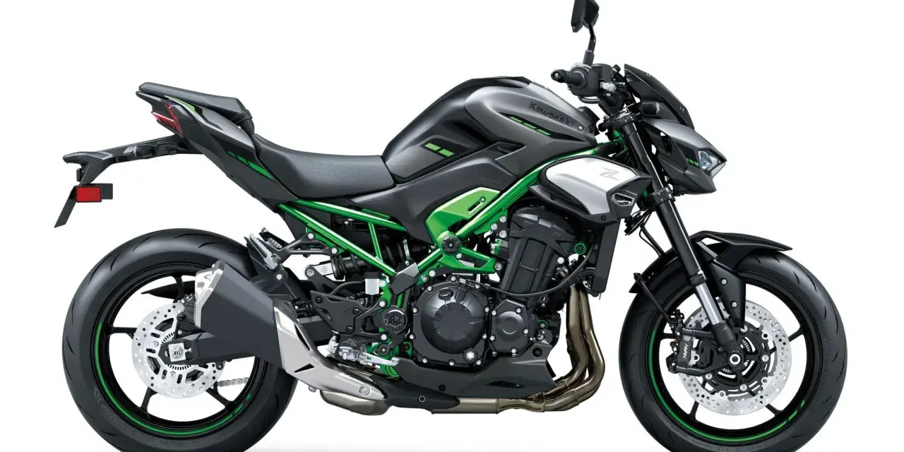 Czarny motocykl Kawasaki Z900 z zielonym stelażem i akcentami. Potężna maszyna gotowa na przygodę.