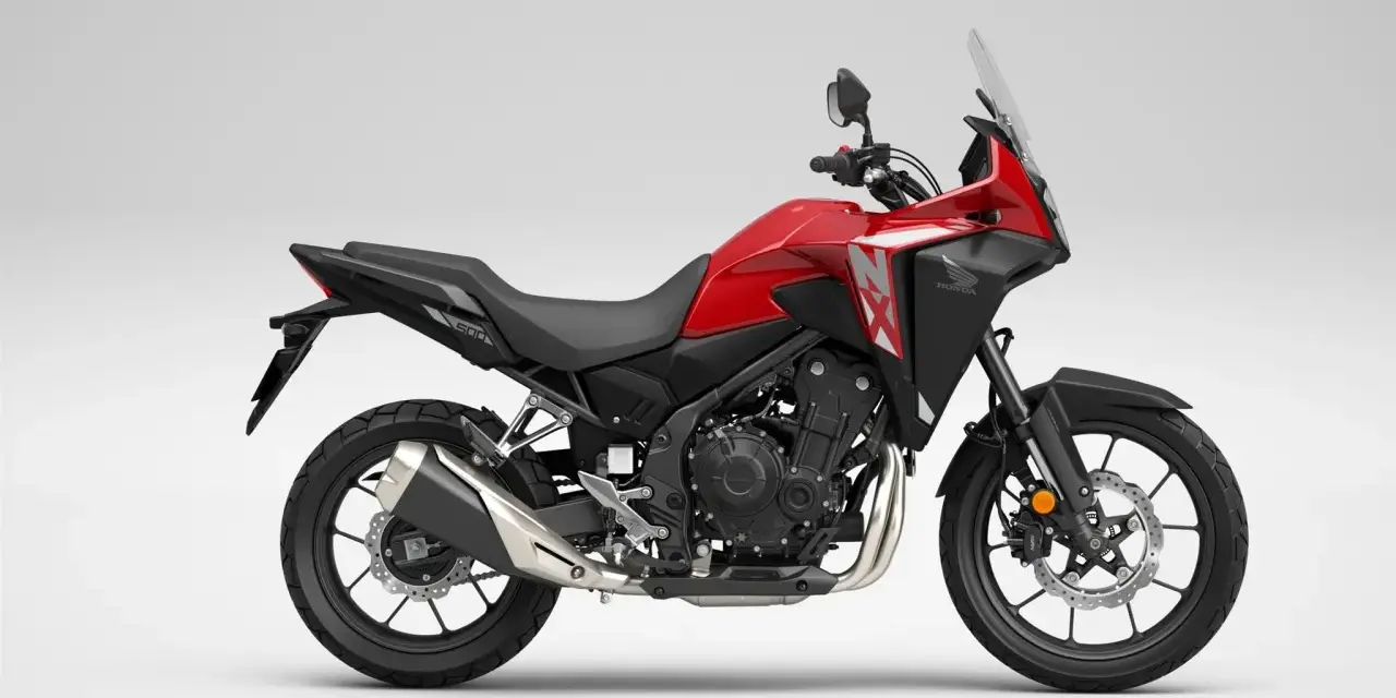 Czerwony motocykl Honda NX 500 z czarnymi elementami, gotowy na przygodę.