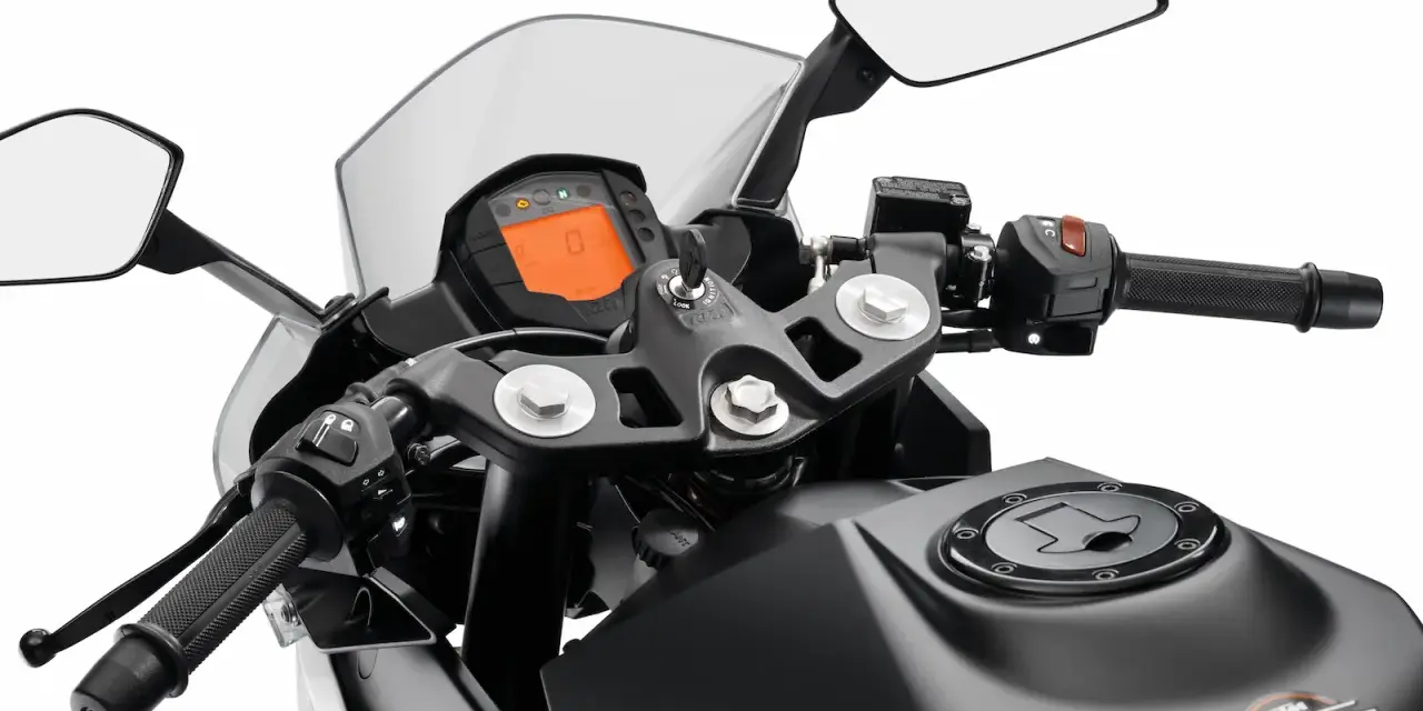 Widok na kierownicę motocykla KTM z cyfrowym wyświetlaczem, lusterkami i uchwytem.