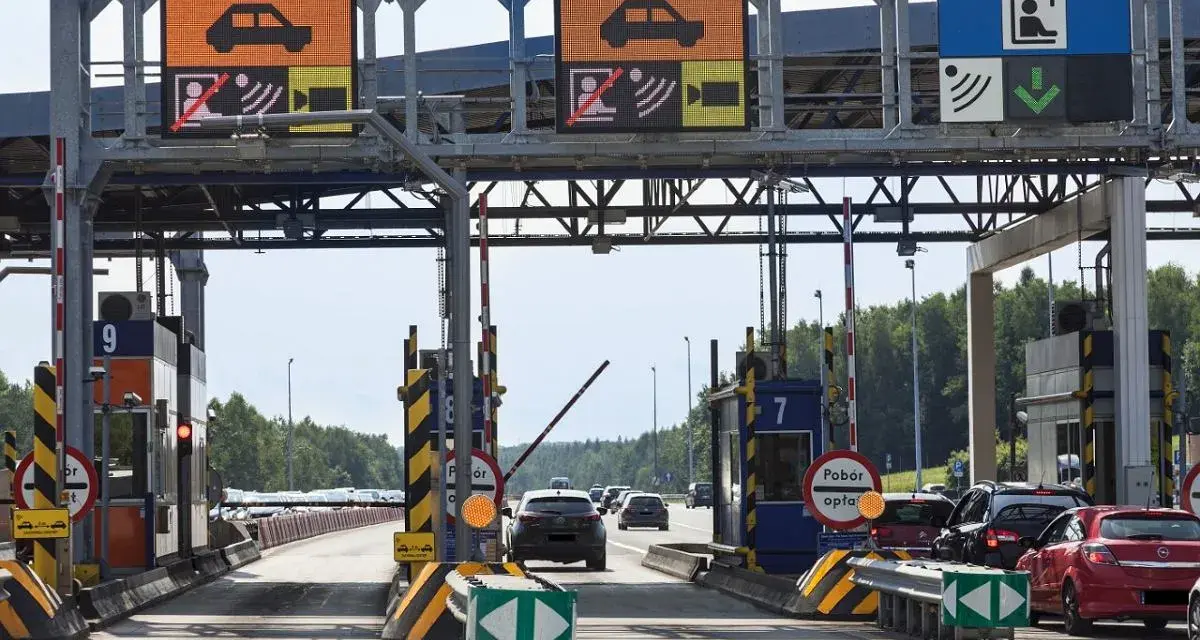 Pobieranie opłat na autostradzie A4. Samochody zbliżają się do bramek, na których wyświetlane są informacje o opłatach.