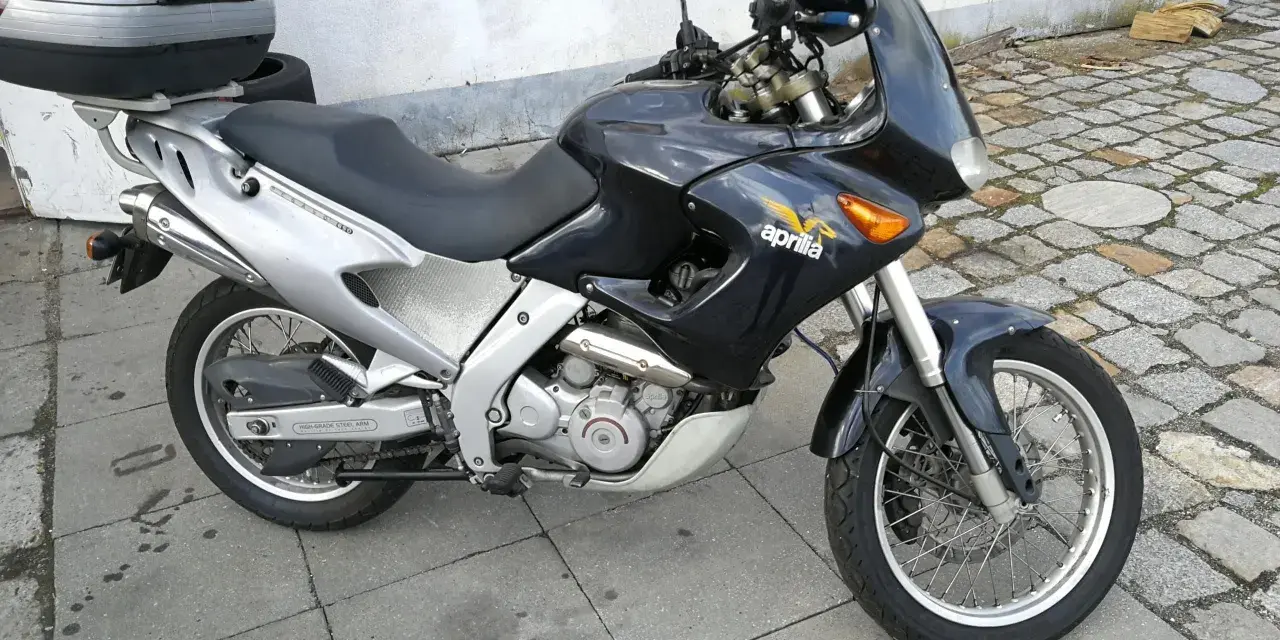 Czarny motocykl Aprilia Pegaso 650 z kufrem na bagaż, gotowy na przygodę.