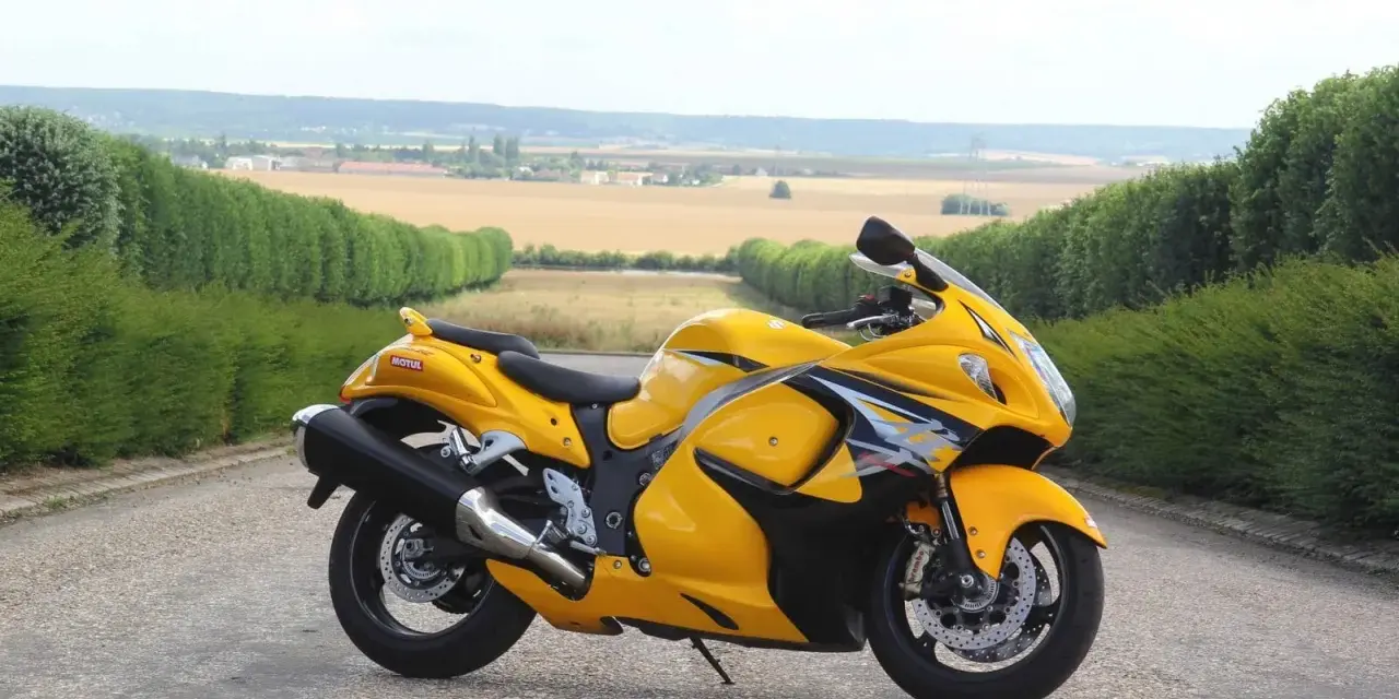 Żółty Suzuki Hayabusa na tle pól i zielonych żywopłotów. Sprawdź aktualną suzuki hayabusa cena!