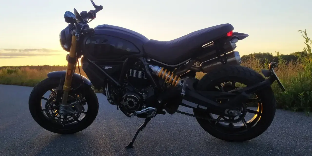 Czarny Ducati Scrambler 1100 na tle zachodzącego słońca. Idealny na wieczorną przejażdżkę.