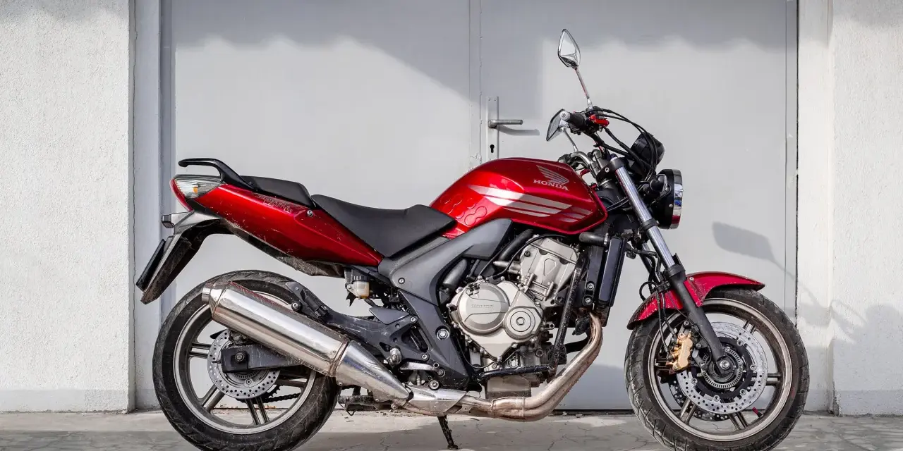 Czerwony motorower Honda Hornet, idealny do miasta. Zastanawiasz się, ile kosztuje motorower tej klasy?