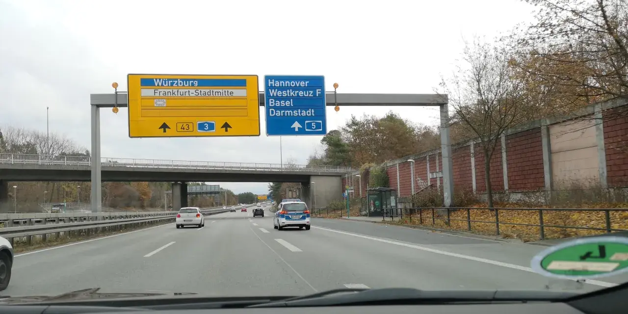 Autostrada A5. Znaki kierują do Würzburga, Frankfurtu, Hanoweru i Darmstadt. Na drodze ruch samochodowy.