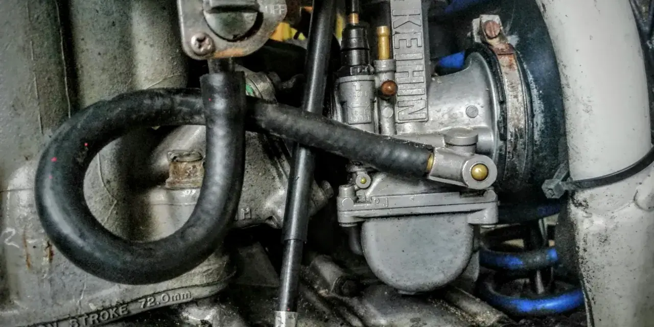 Gaźnik motocyklowy z widoczną dyszą wolnych obrotów.