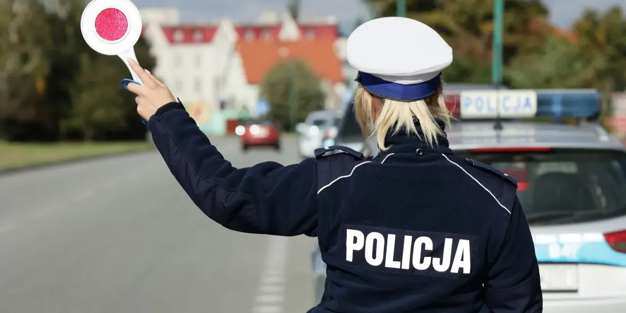 Policjantka z tarczą zatrzymuje ruch. Kierowca, który już raz dostał mandat, musi uważać, by nie popełnić kolejnego wykroczenia.