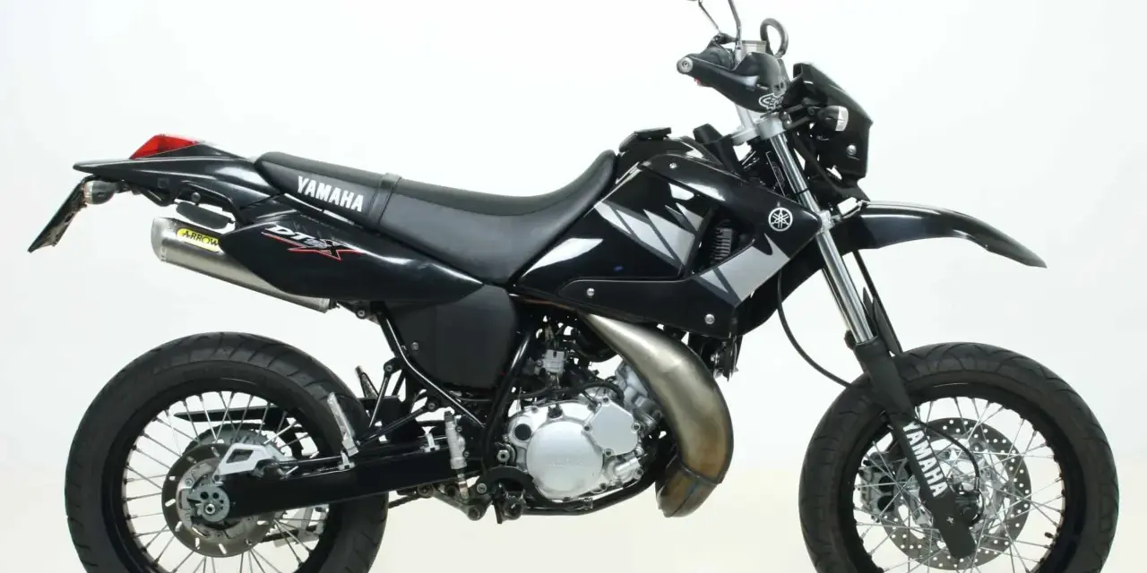 Czarny motocykl Yamaha DT 125 z naklejkami DTX i wydechem Arrow. Idealny do miasta i terenu, sprawdź yamaha dt 125 dane techniczne.