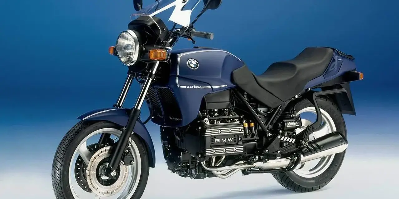 Granatowy motocykl BMW K75 z owiewką i widocznym silnikiem. Szczegółowe dane techniczne BMW K75 dostępne w sieci.