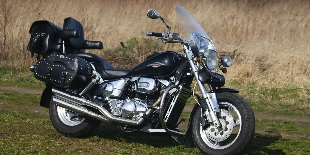 Czarny Suzuki Marauder z sakwami i szybą, gotowy na podróż przez jesienne krajobrazy.