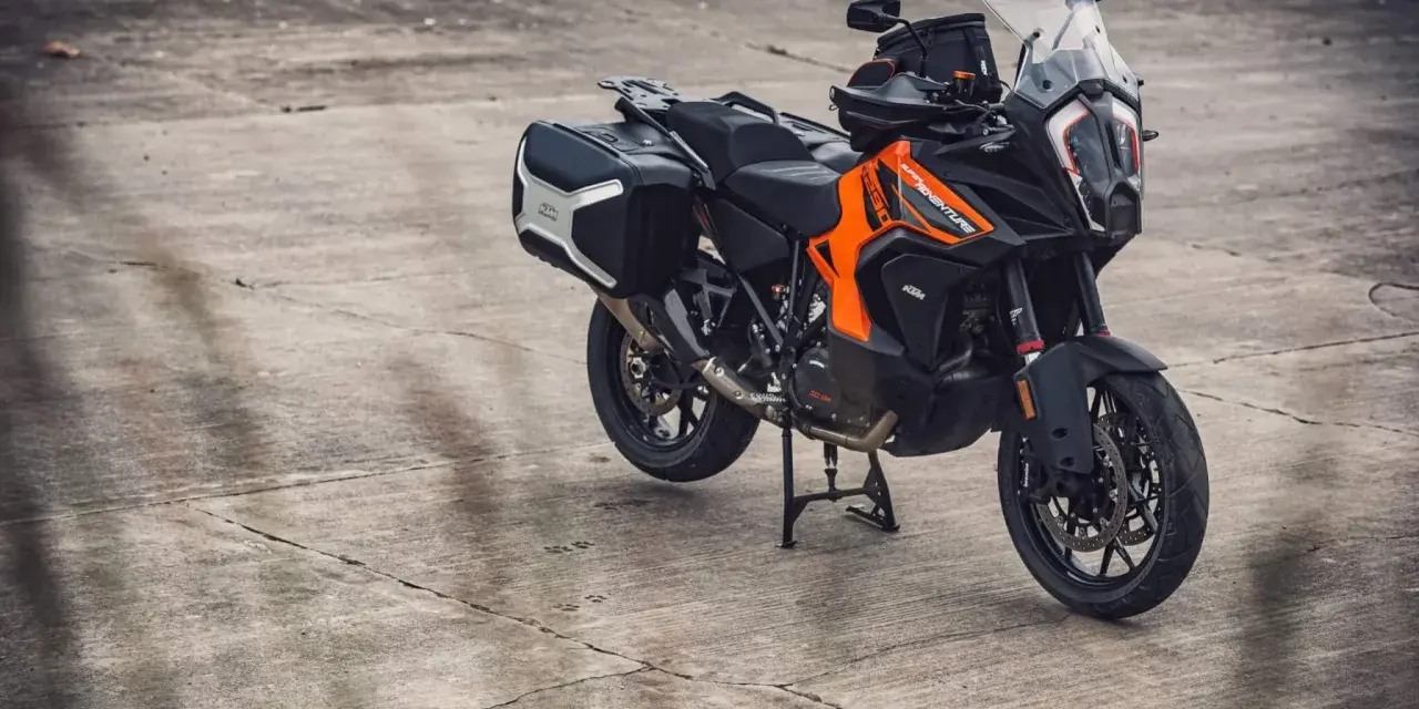 Pomarańczowo-czarny motocykl KTM 1290 Super Adventure z kuframi, gotowy na każdą wyprawę.
