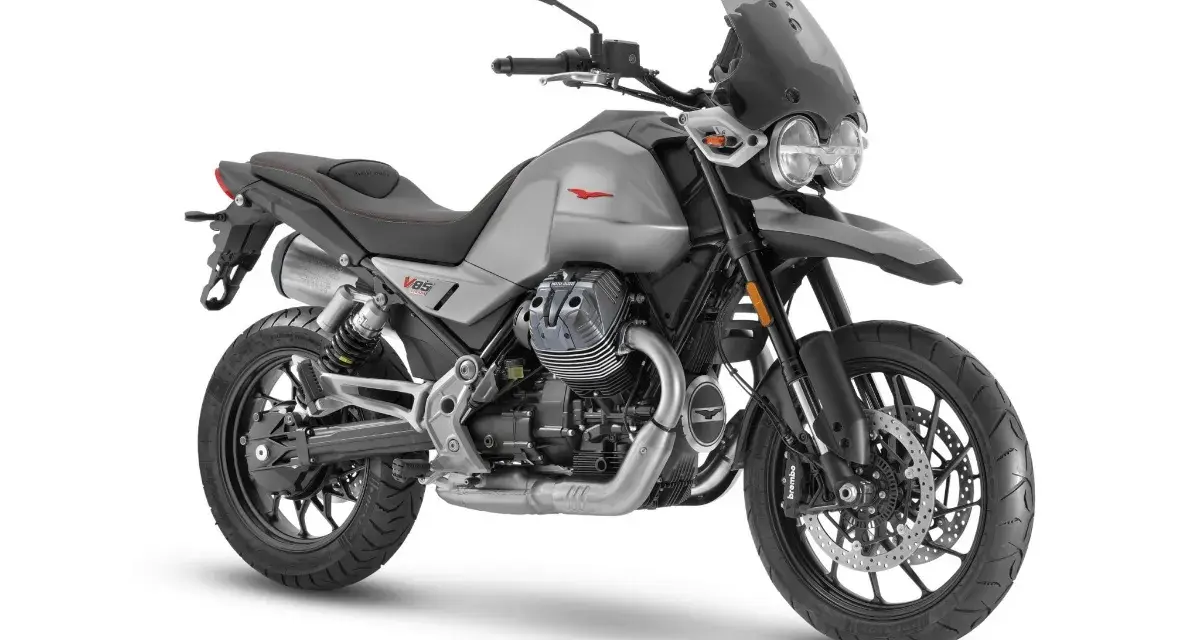 Srebrny motocykl Moto Guzzi V85 TT z charakterystycznym silnikiem V-twin, gotowy na przygodę.