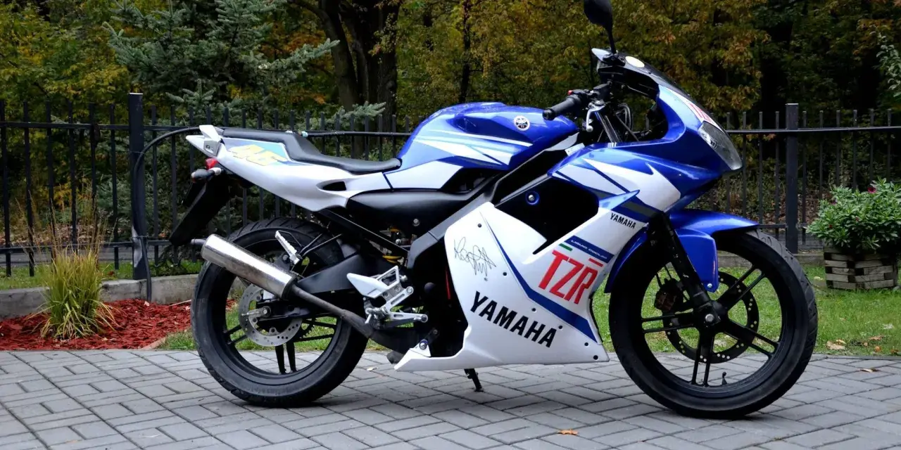 Sportowy motocykl Yamaha TZR 50 w niebiesko-białych barwach, gotowy do jazdy. Sprawdź jego atrakcyjną yamaha tzr 50 cena!