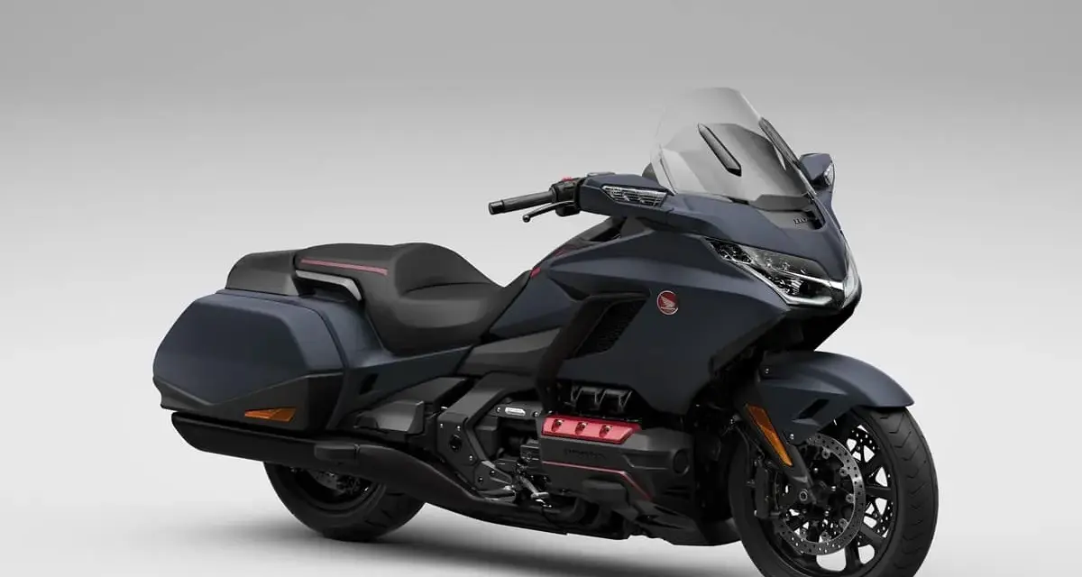 Ciemnoszary motocykl Honda Gold Wing z czarnym siedzeniem i kuframi, gotowy na dalekie podróże.