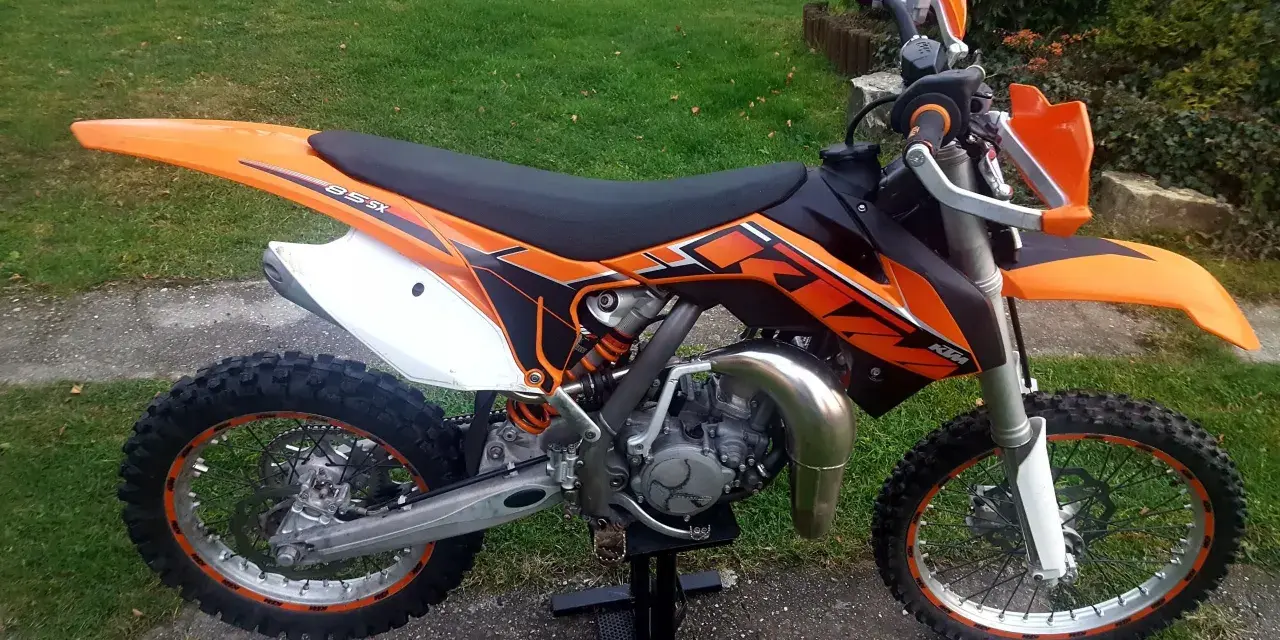 Pomarańczowy KTM SX 85 gotowy do jazdy, z pewnością osiągnie imponującą prędkość maksymalną.