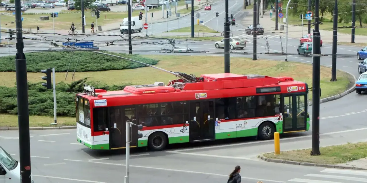 Czerwony trolejbus z napisem "Lublin" na ulicy. Zastanawiasz się, jak dojadę do celu? Ten pojazd to dobry trop.
