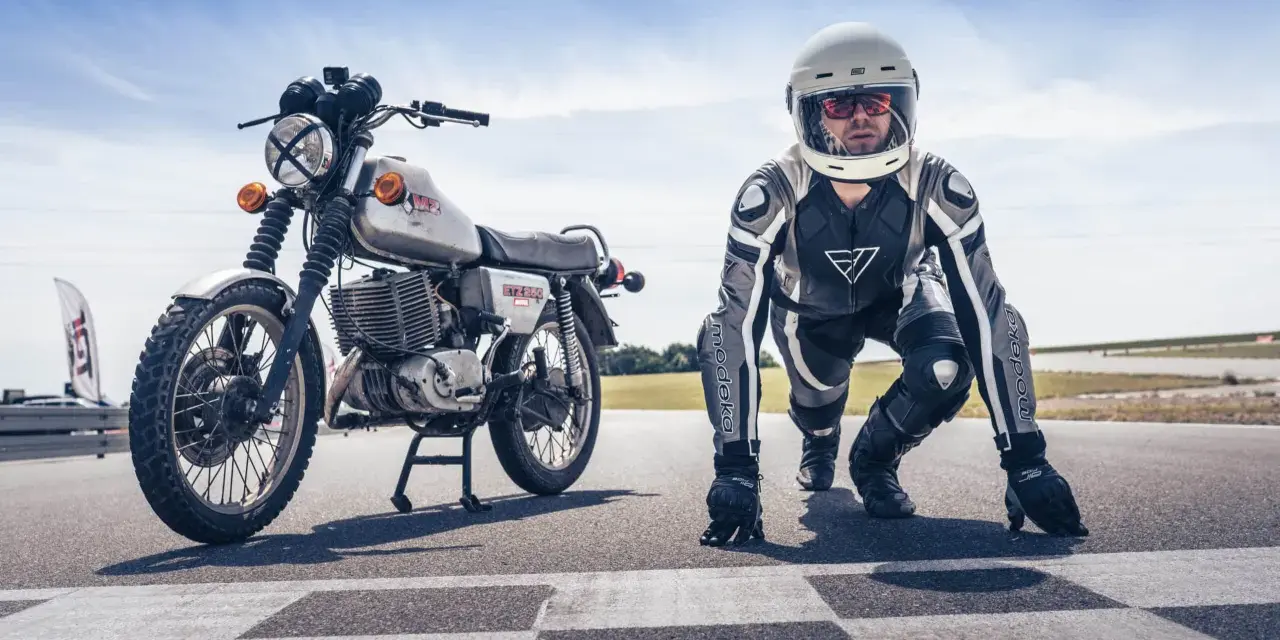Motocykl MZ ETZ 250 i zawodnik w kombinezonie i kasku na starcie wyścigu. Gotowi do startu!