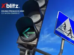Sygnalizacja świetlna strzałki w lewo świeci na zielono. Obok znak drogi dla rowerzystów i pieszych.