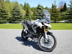 Biały motocykl Triumph Tiger 900 na brukowanej nawierzchni. Poznaj jego imponujące triumph tiger 900 dane techniczne.