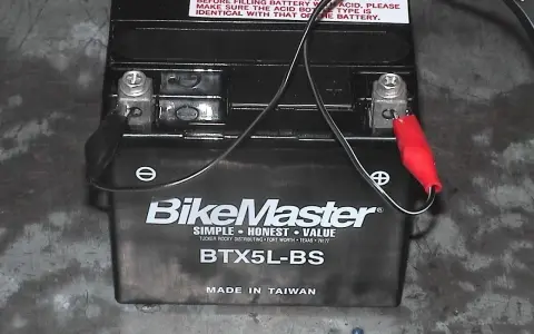Akumulator motocyklowy BikeMaster BTX5L-BS podłączony do ładowarki. Zastanawiasz się, jakim prądem ładować akumulator? Sprawdź instrukcję.