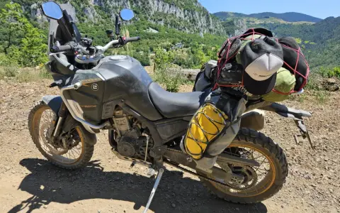 Motocykl Kove 800X Rally gotowy na przygodę, z bagażem na wyprawę po górskich drogach.