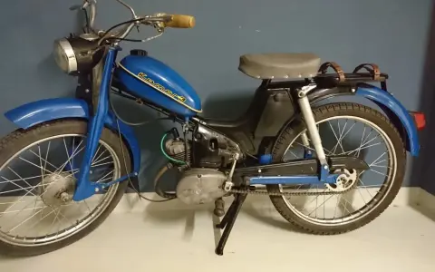 Niebieski motorower Komar, jeden z klasycznych polskich motorowerów, z charakterystycznym napisem na baku.