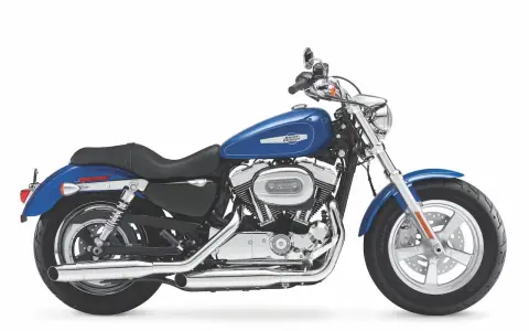 Błękitny motocykl Harley Sportster 1200 z chromowanymi elementami, gotowy na drogę.
