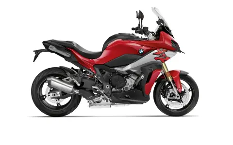 Czerwony motocykl sportowo-turystyczny BMW XR z szarymi akcentami i czarnym siedzeniem, gotowy na przygodę.