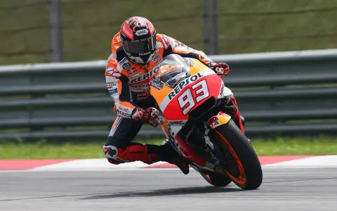 Motocyklista w kombinezonie Repsol Honda z numerem 93 wykonuje ostry zakręt, stosując technikę przeciwskrętu.