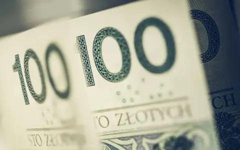 Sto złotych na zakup motocykla. Widoczne fragmenty banknotów 100 zł.