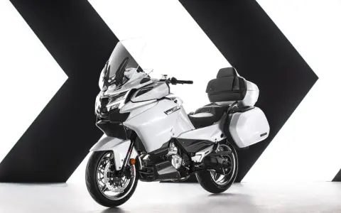 Biały, luksusowy motocykl turystyczny z kuframi, gotowy na dalekie podróże. Chińskie motocykle turystyczne oferują komfort i styl.