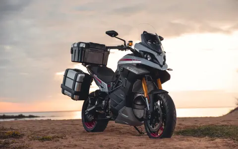 Motocykl z kuframi na plaży, idealny na podróże z prawem jazdy kat B. Motocykl 250 cc.