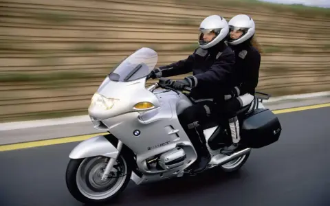 Para podróżuje na srebrnym BMW R 1100 RT. Choć motocykl ten ma swoje wady, podróż wygląda na komfortową.